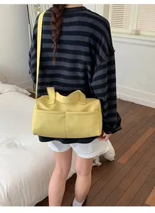 Detail view of bright yellow textured PU leather tote bag shown on a model
