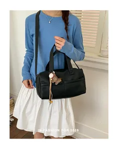 Black litchi grain leather crossbody tote bag with brown horse charm in lifestyle setting