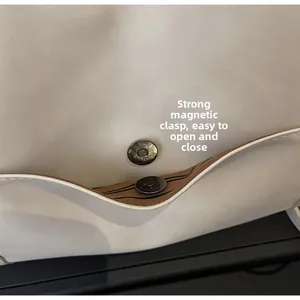 Detail of strong magnetic closure and striped lining on cream faux leather tote bag