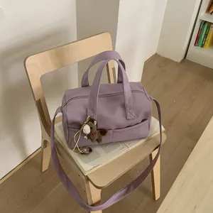 Close-up of lavender lychee pattern leather Boston bag with a cute pony charm on a chair