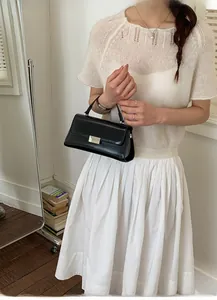 Detail of a black leather square handbag with silver metal buckle for professional women