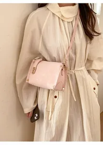 Dettaglio della borsa a tracolla in pelle PU rosa con borchie dorate e tracolla lunga elegante