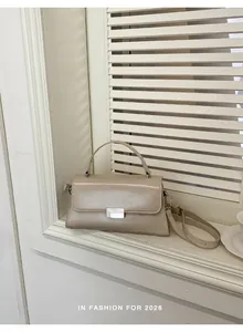 Detailed view of beige PU leather handbag with silver striped lock and sleek finish