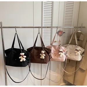 Detail view of large tote bags in four colors with cute teddy bear plush charms