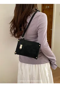 Dettaglio di una borsa a tracolla retrò nera minimalista con eleganti finiture dorate