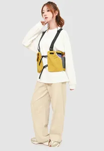 Detail view of mustard yellow tactical chest bag with adjustable black nylon straps