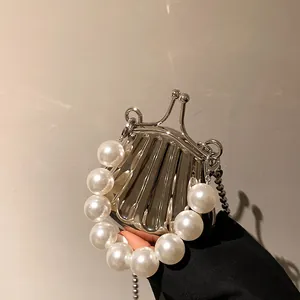 Silberne Abendtasche in Muschelform mit Perlengriff und eleganter Kettenriemen