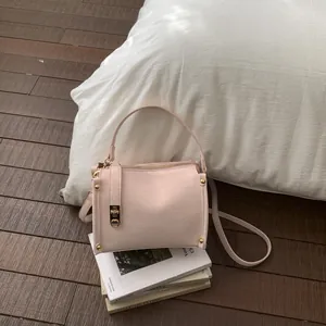Dettaglio della borsa rosa in finta pelle testurizzata con eleganti finiture in metallo oro