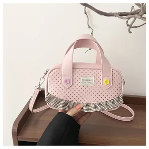 Detail of pink mini crossbody bag with lace edges and floral button accents