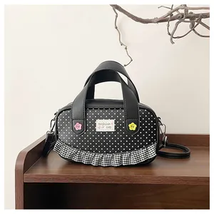 Close-up of black polka dot handbag with lace edges and decorative floral accents
