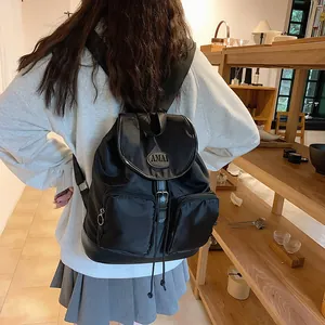Black waterproof nylon backpack with flap cover and large capacity shown on model