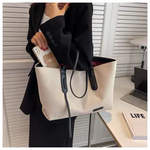 Detail showing high capacity of minimalist canvas tote with contrast leather straps