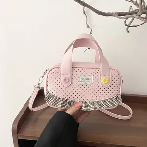 Pink polka dot crossbody bag with lace trim and cute flower charms for spring