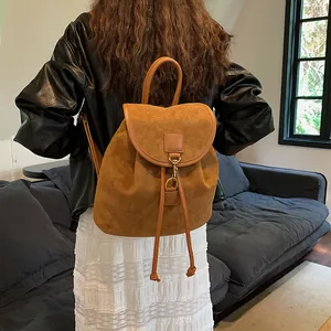 Zaino vintage in velluto marrone con coulisse e gancio in metallo indossato donna