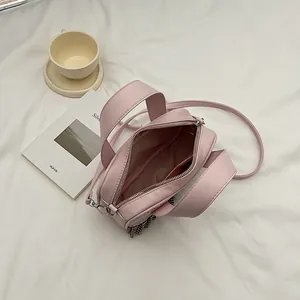 Pink PU leather square handbag with lace trim and interior storage view on soft fabric