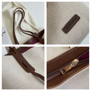 Detail view of canvas tote bag showing leather straps, gold zipper, and brand logo