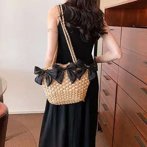 Sac cabas en paille fait main avec nœuds noirs décoratifs pour un look d'été décontracté