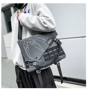 Detail of gray messenger bag with metal chain and straps worn by male model