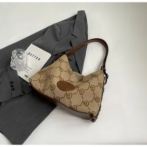 Detailed macro view of retro monogram canvas tote with premium brown leather trim