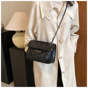 Détail du sac matelassé noir avec fermoir rotatif argenté et texture cuir plissée