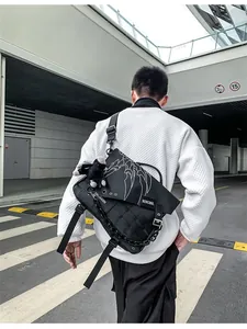 Close-up of black crossbody bag with white claw prints and chain accessory detail