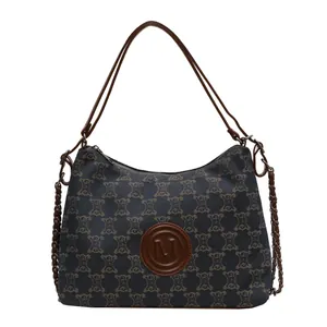 Large capacity navy canvas tote bag with brown monogram pattern and chain shoulder strap