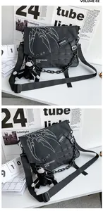 Macro detail of black technical messenger bag featuring white claw graphic and chain
