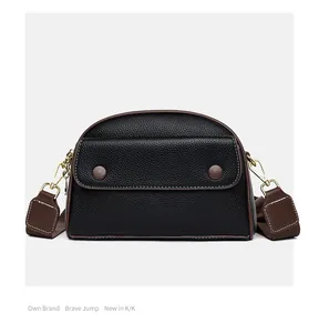 Detailed close-up of litchi grain leather texture and brown contrast stitching on bag