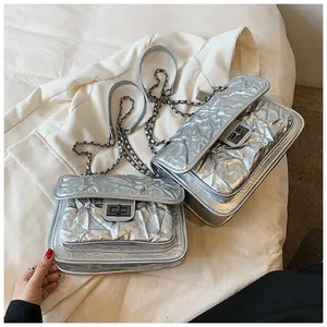 Détail de deux sacs argentés matelassés avec texture plissée et fermoir en métal