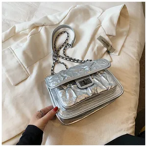 Détail du sac à bandoulière matelassé argenté avec texture métal et bandoulière chaîne