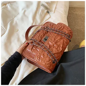 Détail du sac matelassé caramel avec fermoir tournant en argent et bandoulière