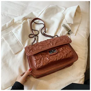 Détails de sac matelassé marron foncé avec texture froissée et chaîne en métal chic