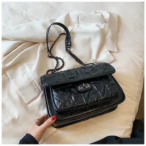 Détail de la texture en cuir matelassé et du fermoir rotatif argenté du sac noir