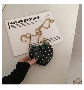Close-up of strawberry heart-shaped chain bag with gold rivets and metallic lock detail