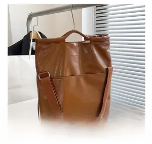 Detailansicht braune Shopper-Tasche mit abnehmbarem Gurt und praktischer Fronttasche