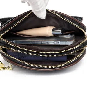 Black pebbled leather crossbody bag showing three large internal storage compartments