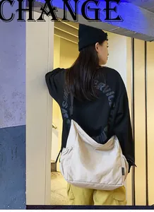 Λεπτομέρεια μπεζ νάιλον τσάντα χιαστί με ρυθμιζόμενο λουράκι και λογότυπο στο πλάι