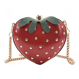 Cute red strawberry heart-shaped crossbody bag with gold chain strap and leaf detail