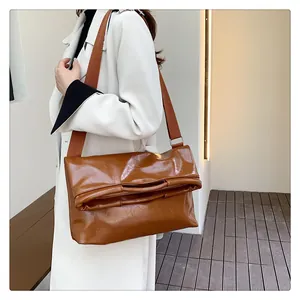 Detailaufnahme der braunen glänzenden Ölwachs-Ledertasche mit breitem Canvas-Gurt