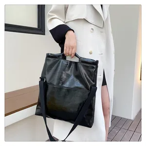 Details der glänzenden schwarzen Tote-Bag aus Kunstleder mit modischem Schultergurt