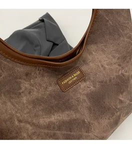 Detail of vintage brown leather tote bag showing soft matte texture and leather logo patch