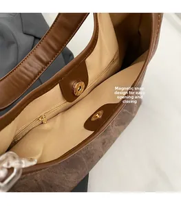 Detail of magnetic snap closure and internal zip pocket on vintage brown shoulder bag