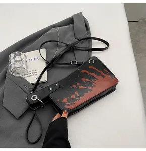 Macro shot of creative blood-splatter cleaver crossbody bag with metallic rivet details