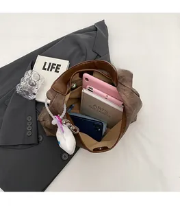 Top view of large brown textured tote bag showing spacious interior with tablet and books