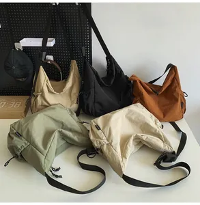 Λεπτομέρεια από νάιλον τσάντες χιαστί σε διάφορα χρώματα με κορδόνια και φαρδύ λουρί