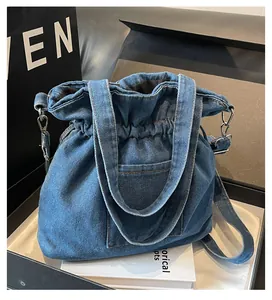 Detail of blue denim bucket bag with pleated pocket and detachable shoulder strap