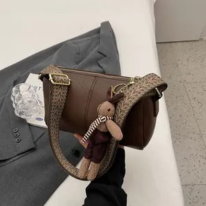 Deep brown cylinder shoulder bag with vintage jacquard strap and cute rabbit pendant