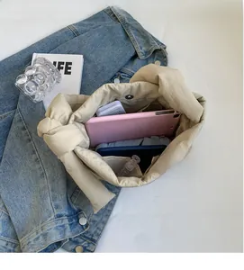Spacious interior of beige quilted puffer bag showing tablet and daily essentials