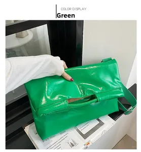 Detailansicht der hellgrünen glänzenden Ledertasche mit einem breiten Stoffschultergurt