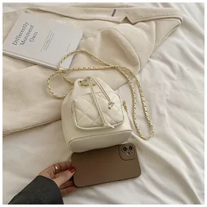 Détail du sac seau matelassé beige avec bandoulière chaîne et fermeture à cordon